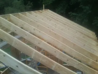 New roof rafters set over an addition before sheathing in Mebane