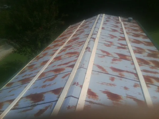 Rusted metal roof panels with new wood purlins before replacement — Storm Damage Roof Repair in Mebane by Roofing Brothers
