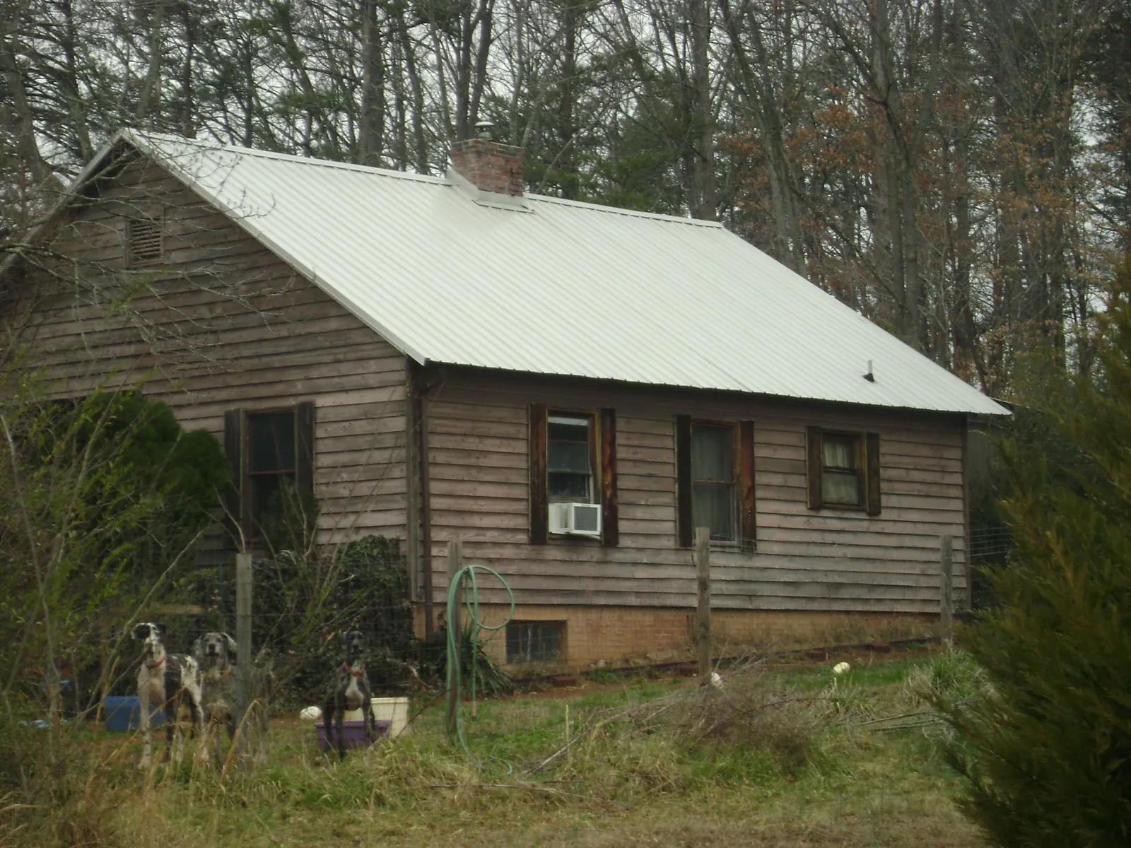 White metal roof on an old wood sided farmhouse, from a Metal Roof Installation job in Mebane